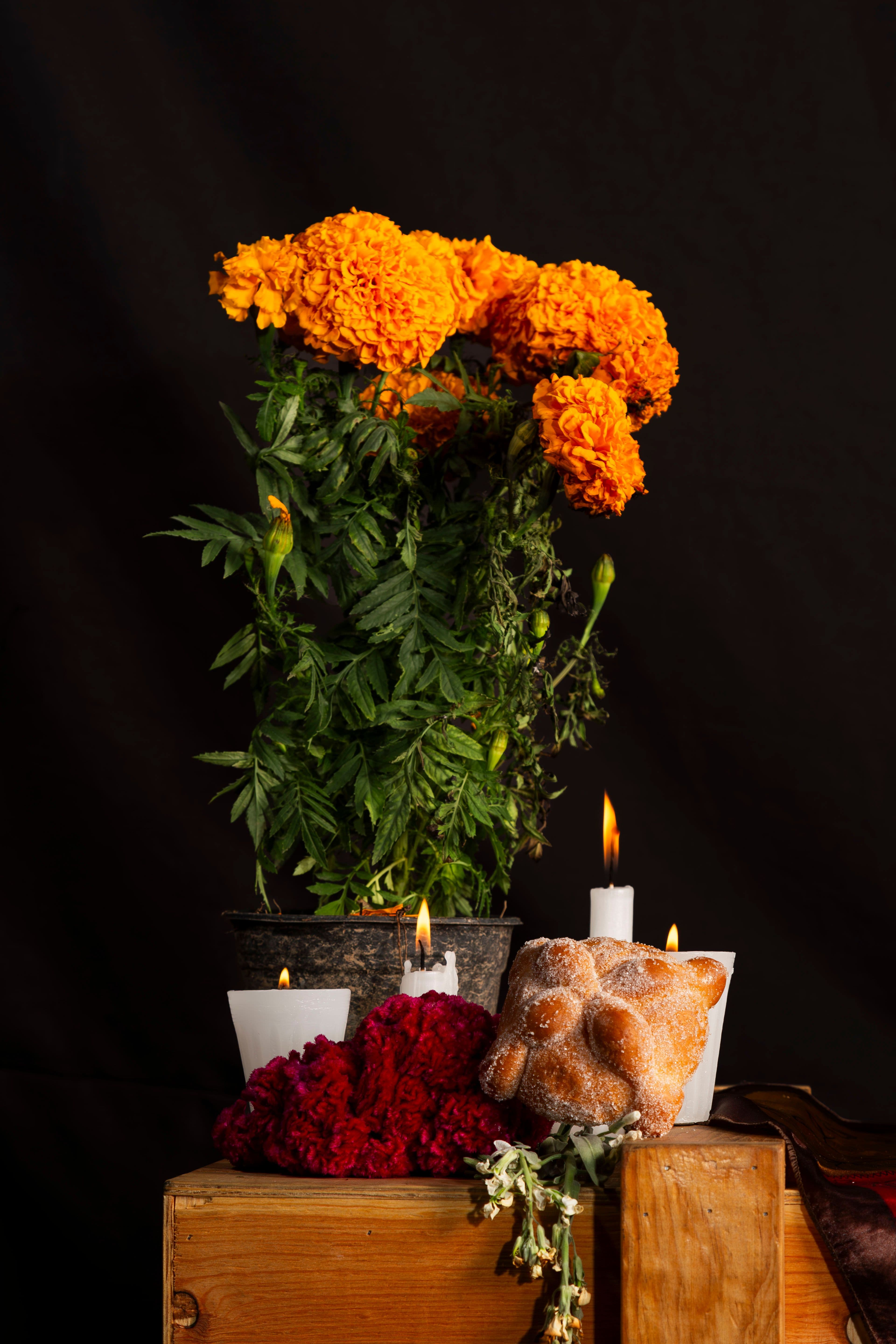 Ofrenda con flores de cempasúchil, velas encendidas y pan de muerto